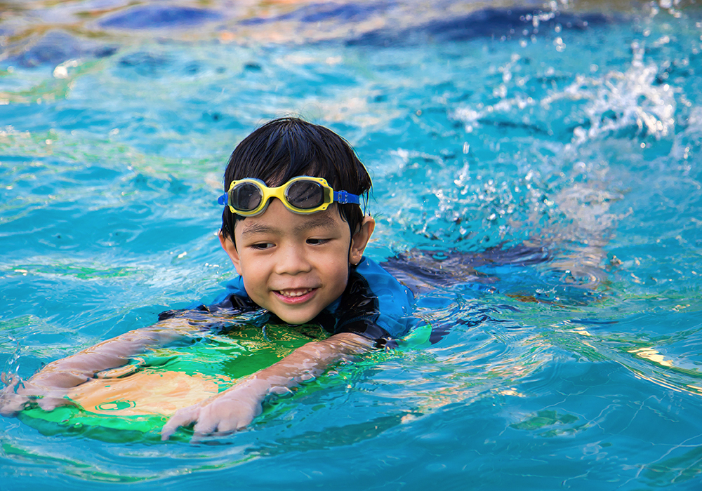 A child swimming with a board.